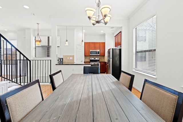 unfurnished dining area with recessed lighting, ornamental molding, light wood-type flooring, baseboards, and a notable chandelier