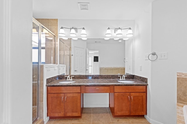 full bath featuring a shower stall, tile patterned flooring, a sink, and double vanity