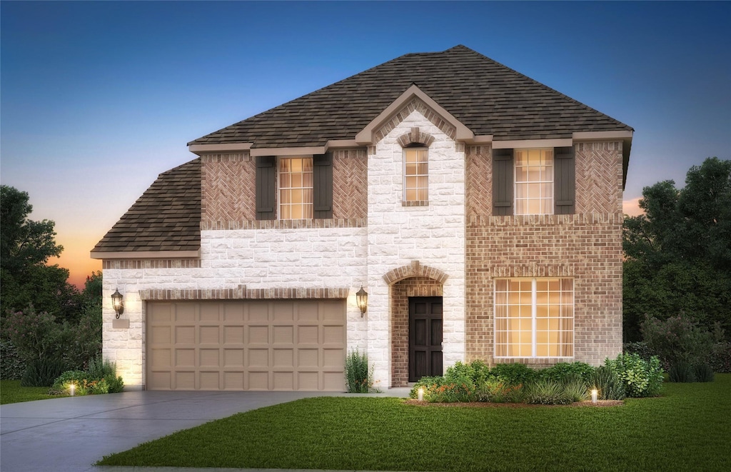 view of front of home with a garage and a lawn