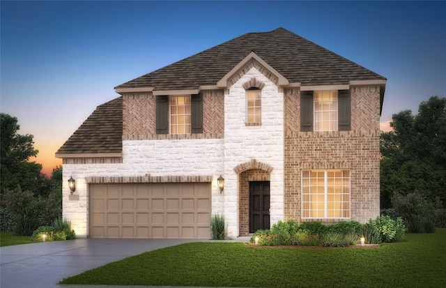 view of front of home with a garage and a lawn