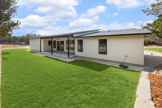 back of property featuring ceiling fan, a patio area, and a lawn