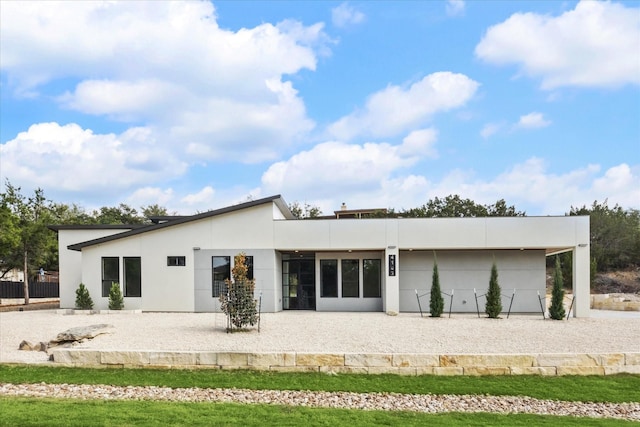 back of property featuring a garage and a patio area