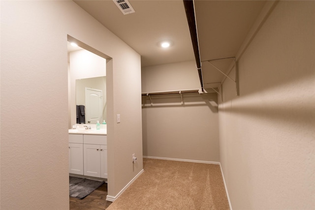 walk in closet featuring light colored carpet