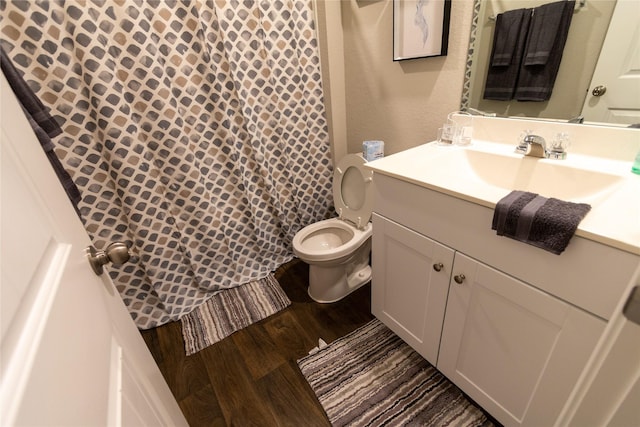 bathroom with vanity, toilet, and hardwood / wood-style floors