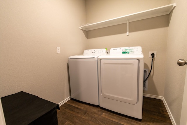 clothes washing area with dark hardwood / wood-style floors and washer and clothes dryer