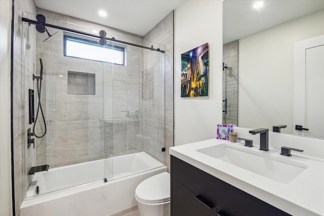 full bathroom featuring vanity, enclosed tub / shower combo, and toilet