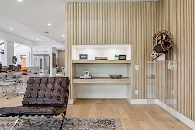 kitchen featuring built in shelves, built in refrigerator, and light wood-type flooring