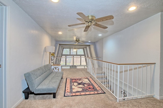 sitting room featuring carpet flooring and a textured ceiling