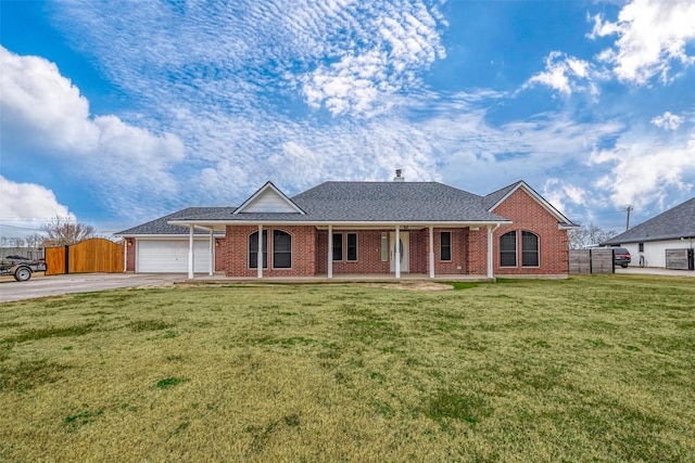 ranch-style house with a garage, a front lawn, and covered porch