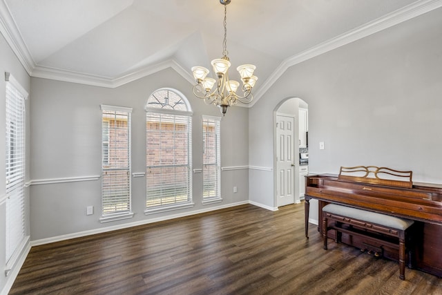 dining space featuring vaulted ceiling, dark hardwood / wood-style floors, a notable chandelier, and ornamental molding