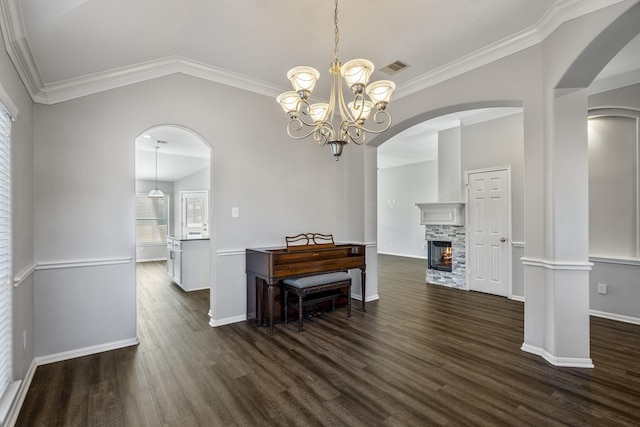 dining space with lofted ceiling, dark hardwood / wood-style flooring, crown molding, and a fireplace