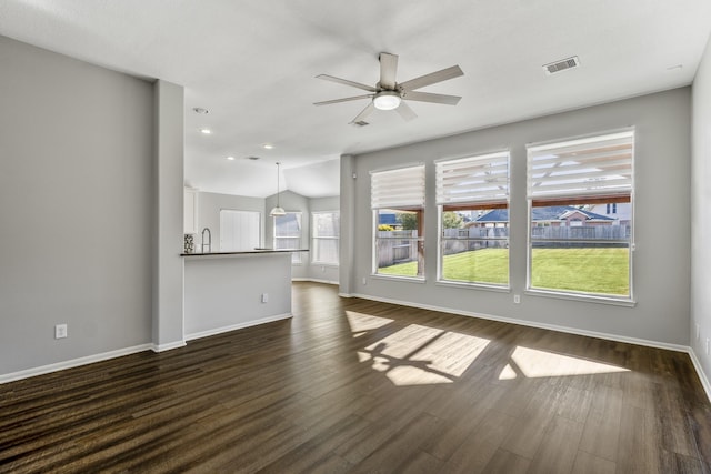 unfurnished living room with dark wood-type flooring, ceiling fan, lofted ceiling, and sink