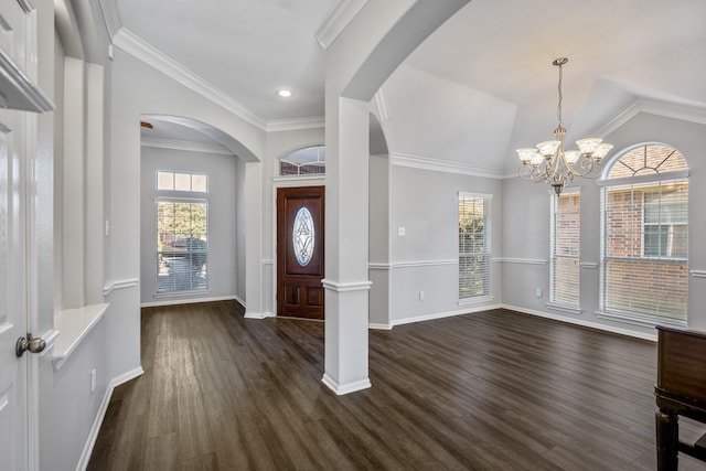 entryway featuring an inviting chandelier, ornamental molding, lofted ceiling, and dark hardwood / wood-style floors