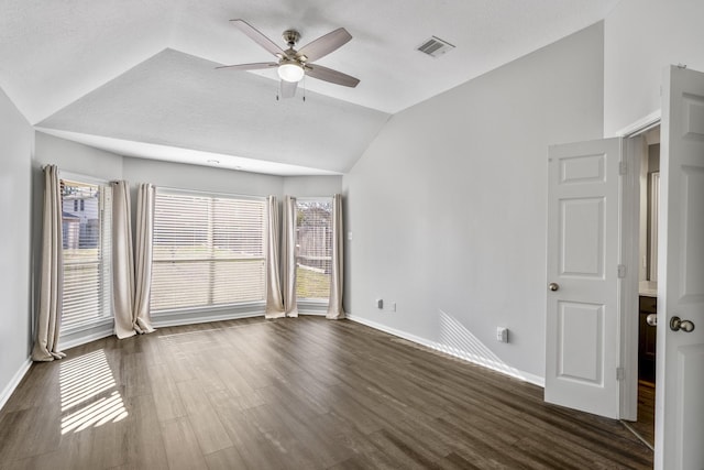 spare room featuring vaulted ceiling, plenty of natural light, ceiling fan, and dark hardwood / wood-style flooring