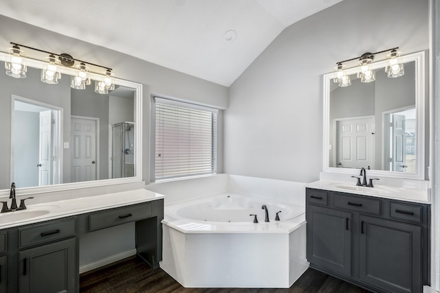 bathroom featuring vanity, hardwood / wood-style floors, vaulted ceiling, and plus walk in shower