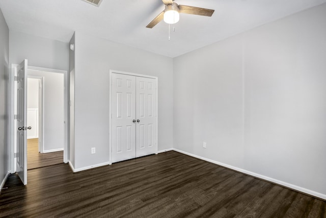 unfurnished bedroom featuring dark hardwood / wood-style floors, a closet, and ceiling fan