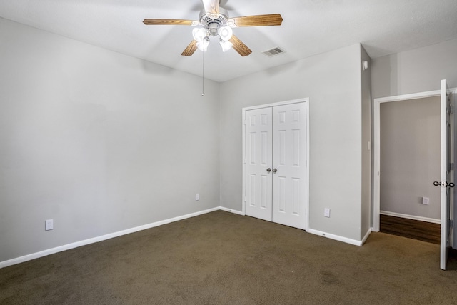 unfurnished bedroom with ceiling fan, dark carpet, and a closet