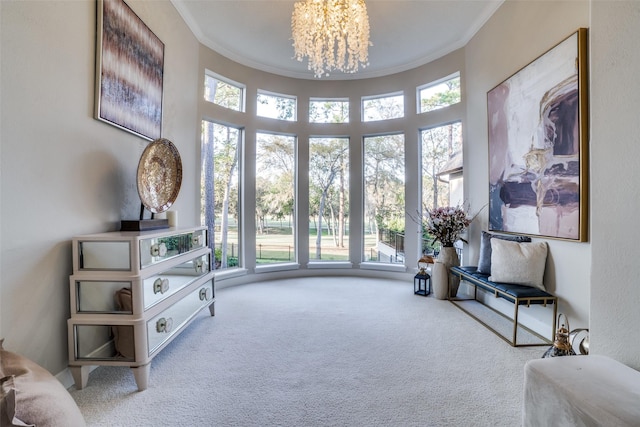 living area with crown molding, carpet floors, a chandelier, and a towering ceiling