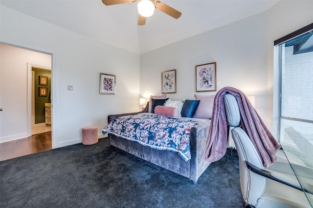 bedroom with dark colored carpet, lofted ceiling, and ceiling fan