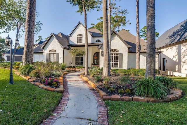 french country style house featuring a front lawn