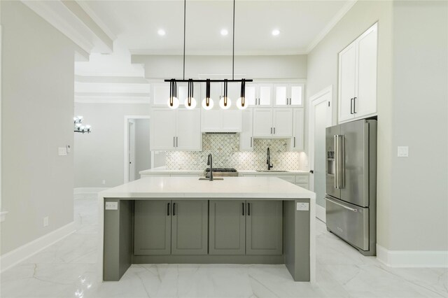 kitchen featuring white cabinets, backsplash, hanging light fixtures, high end fridge, and a center island with sink