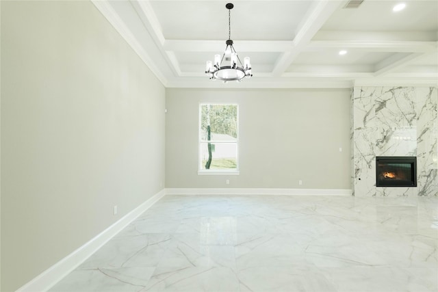 unfurnished living room with beamed ceiling, a premium fireplace, coffered ceiling, crown molding, and an inviting chandelier