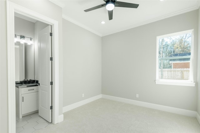 unfurnished bedroom with crown molding, ceiling fan, ensuite bathroom, and light colored carpet