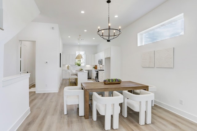 dining space featuring light hardwood / wood-style flooring and a notable chandelier