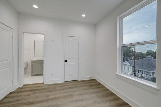 unfurnished bedroom featuring light hardwood / wood-style flooring and ensuite bathroom