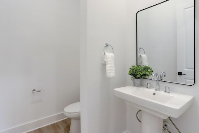 bathroom with hardwood / wood-style floors, sink, and toilet