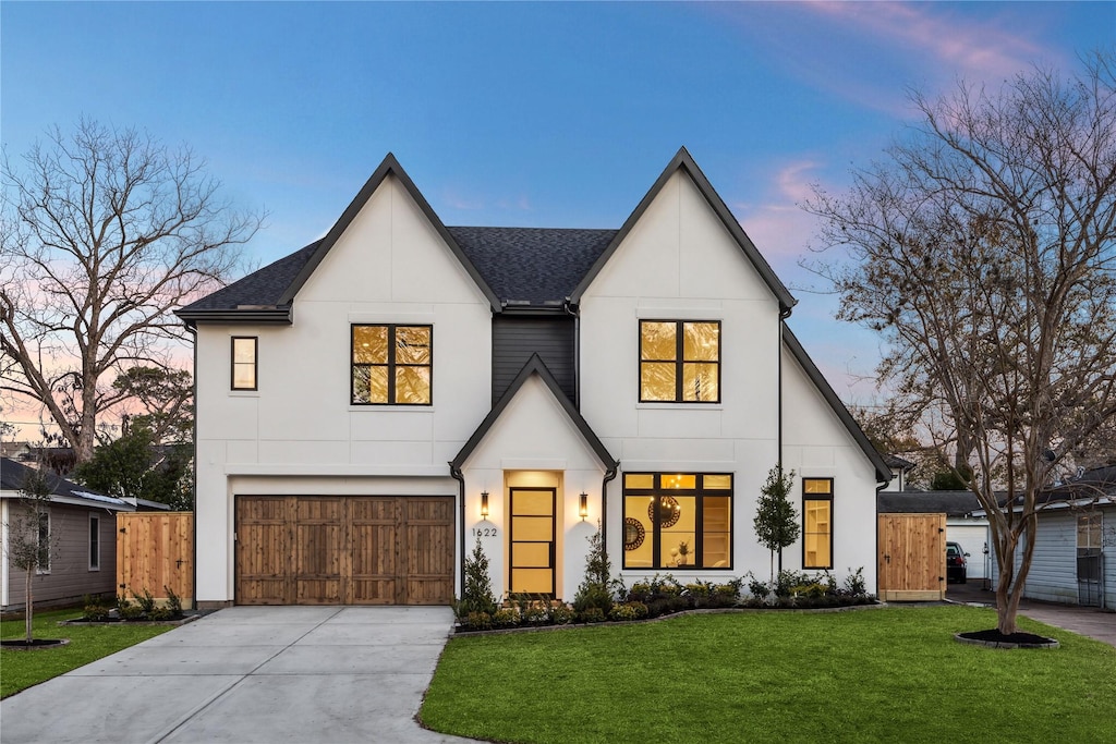 modern farmhouse style home featuring a garage and a lawn