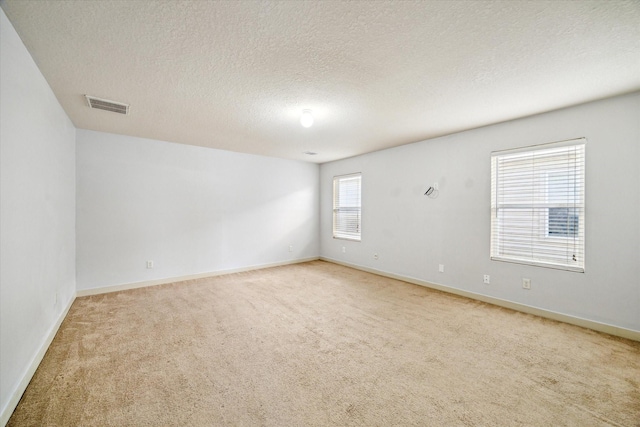 carpeted spare room featuring a textured ceiling