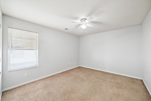 carpeted spare room with ceiling fan and a textured ceiling