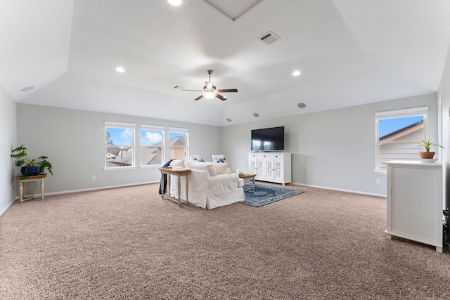 living room featuring ceiling fan, a tray ceiling, and carpet