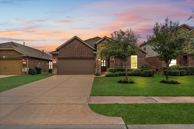 view of front of house featuring a garage and a yard