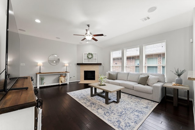 living room featuring ceiling fan, lofted ceiling, dark wood-type flooring, and a fireplace