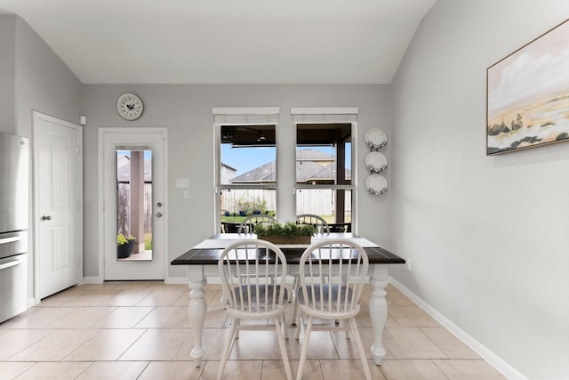 tiled dining room featuring lofted ceiling