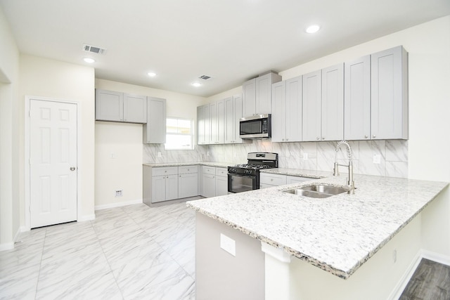 kitchen with sink, gray cabinets, appliances with stainless steel finishes, backsplash, and kitchen peninsula