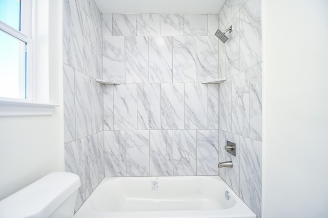 bathroom with tiled shower / bath and toilet