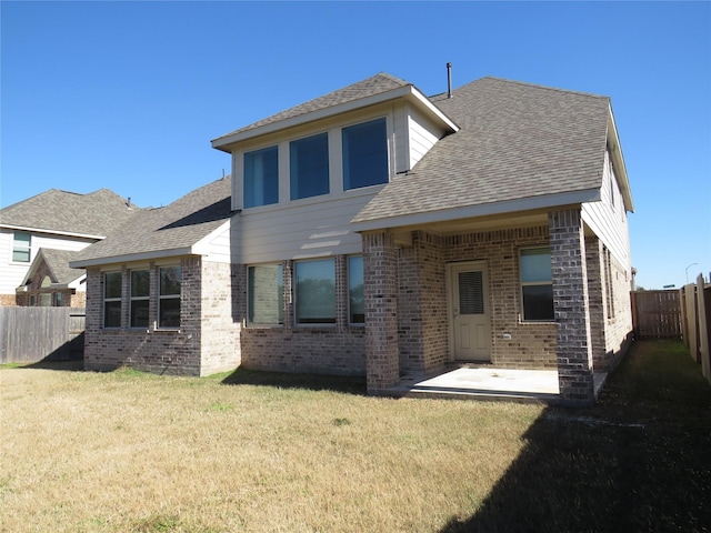 rear view of house with a patio area and a lawn