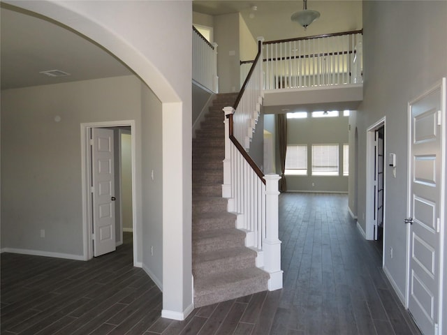 staircase featuring hardwood / wood-style floors and a high ceiling