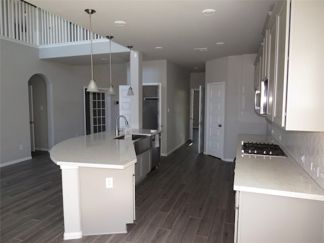 kitchen with sink, decorative light fixtures, a center island with sink, dark hardwood / wood-style flooring, and stainless steel appliances