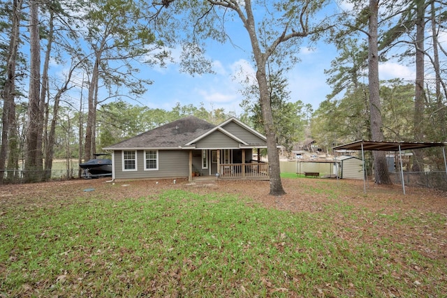 view of front of home featuring a front lawn, a carport, and a storage unit