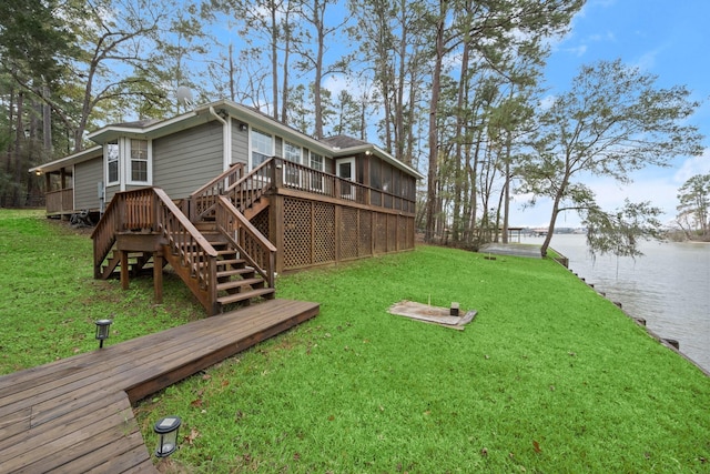 view of yard with a deck with water view and a sunroom