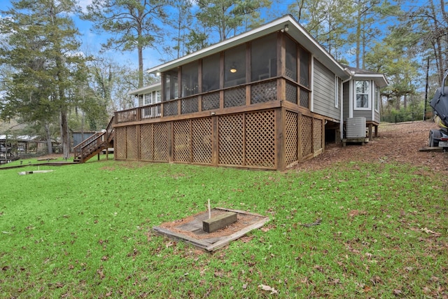 back of property featuring a sunroom and a lawn