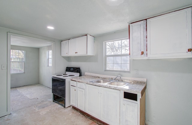 kitchen featuring white cabinetry, range with electric cooktop, sink, and a healthy amount of sunlight