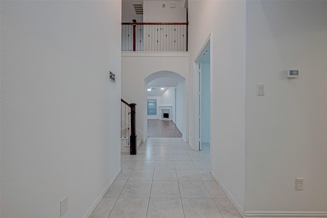 hall with a towering ceiling and light tile patterned floors