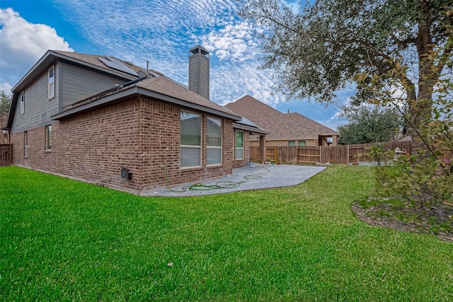 back of property featuring a patio area and a lawn