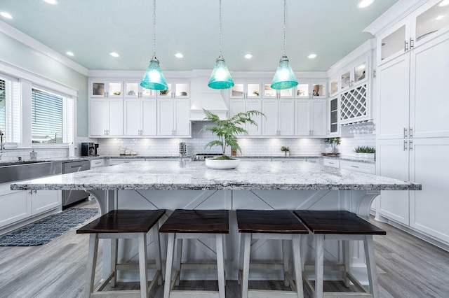 kitchen featuring a kitchen island with sink, white cabinets, and dishwasher