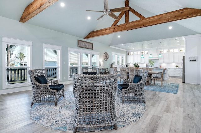 living room with beamed ceiling, plenty of natural light, high vaulted ceiling, and light wood-type flooring